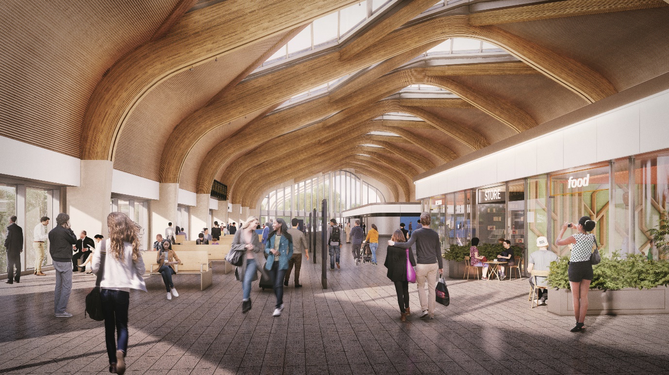 Picture of the station concourse with prefabricated modular roof elements. It also shows  passengers walking around the concourse.