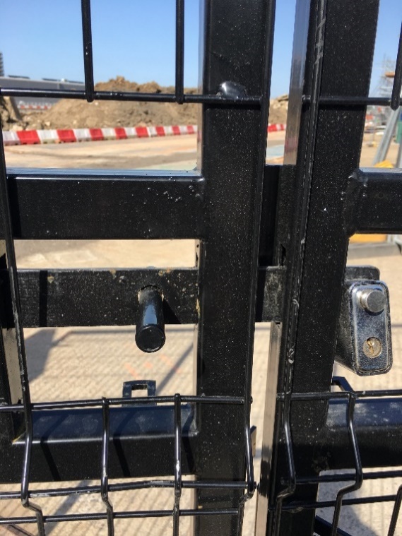 Picture of an unsafe gate closing with a lock with a risk of hand entrapment and pinch that can cause hand entrapment and pinch point