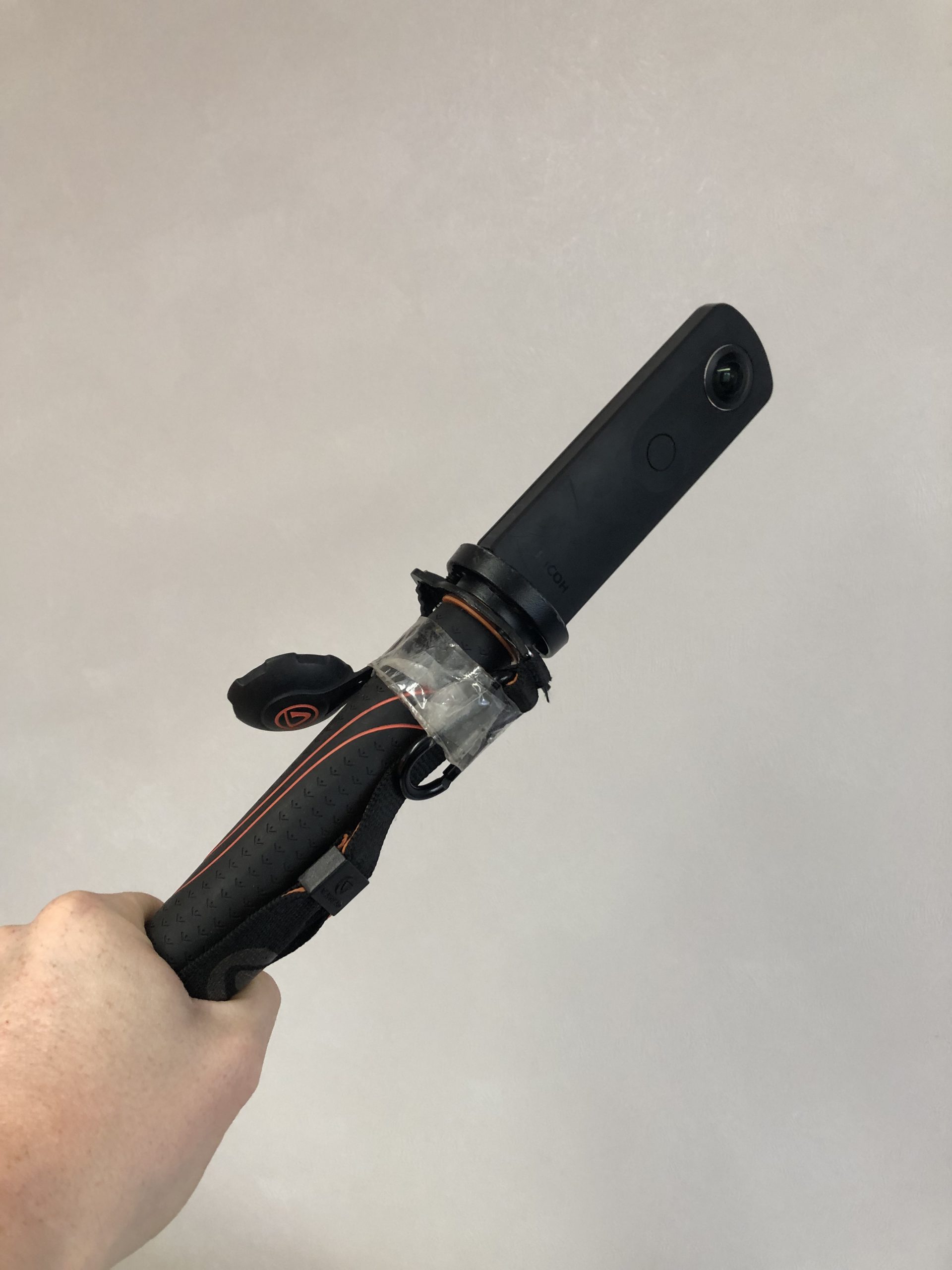 Picture of a Richo Theta camera being held in a hand 