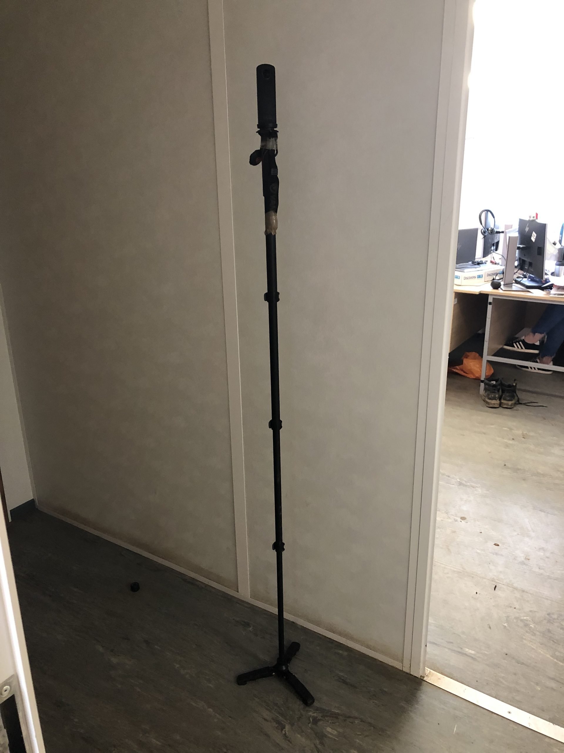 Picture of a camera that is attached to a extendable tripod pole