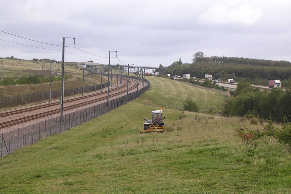 Picture of cutting vehicle in use beside fenced off railway tracks