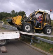 Picture of maintenance tractor on makeshift ramp over fencing