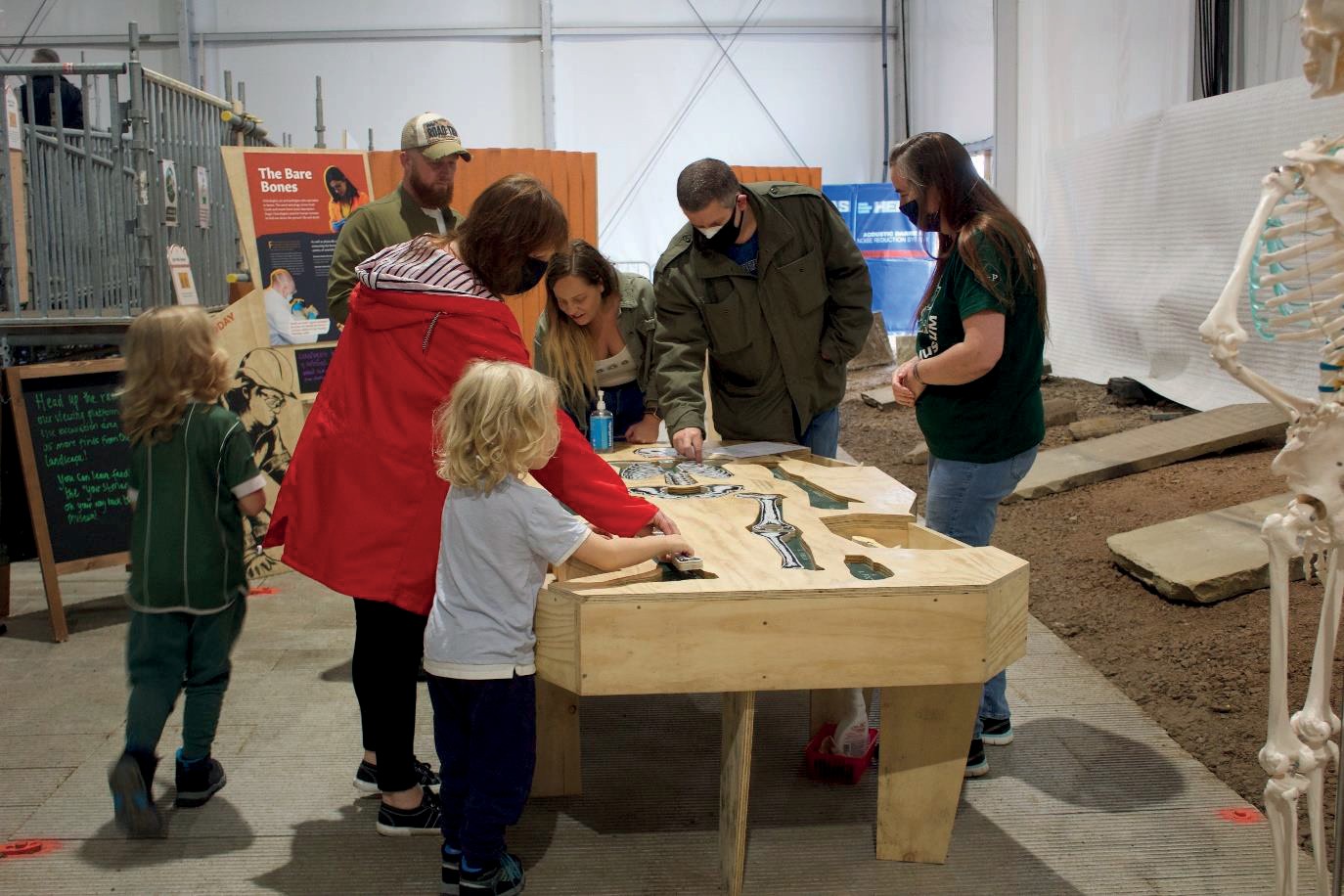  Image of the skeleton puzzle table being enjoyed by people of several ages.