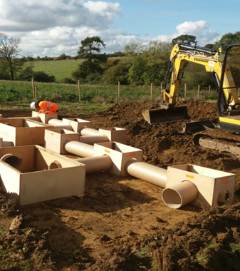 Photo of ABS being built showing pipes laid in the ground.
