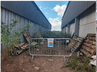 Picture of a barrier beside buildings showing location of waste