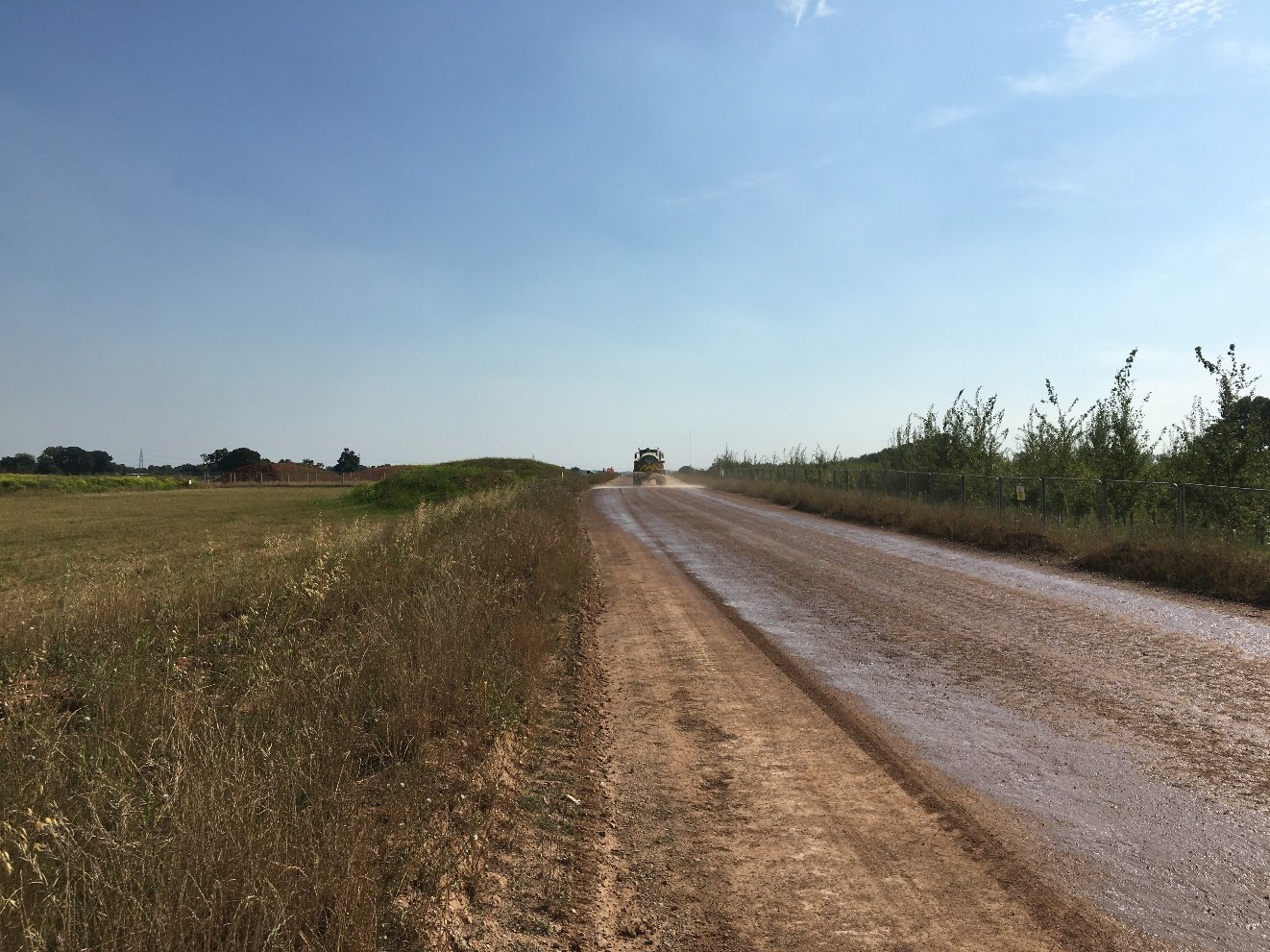 A haul road with grass and trees following single pass.

