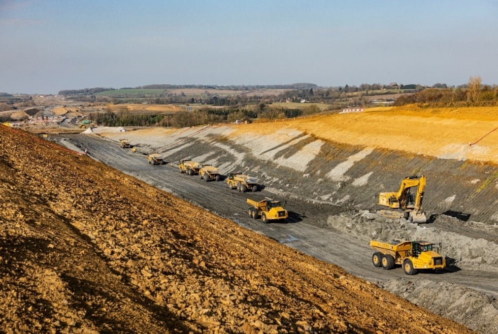 A group of construction vehicles on a road.