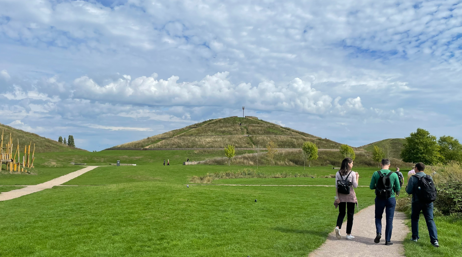 A group of people walking on a path in  Northala Fields 
