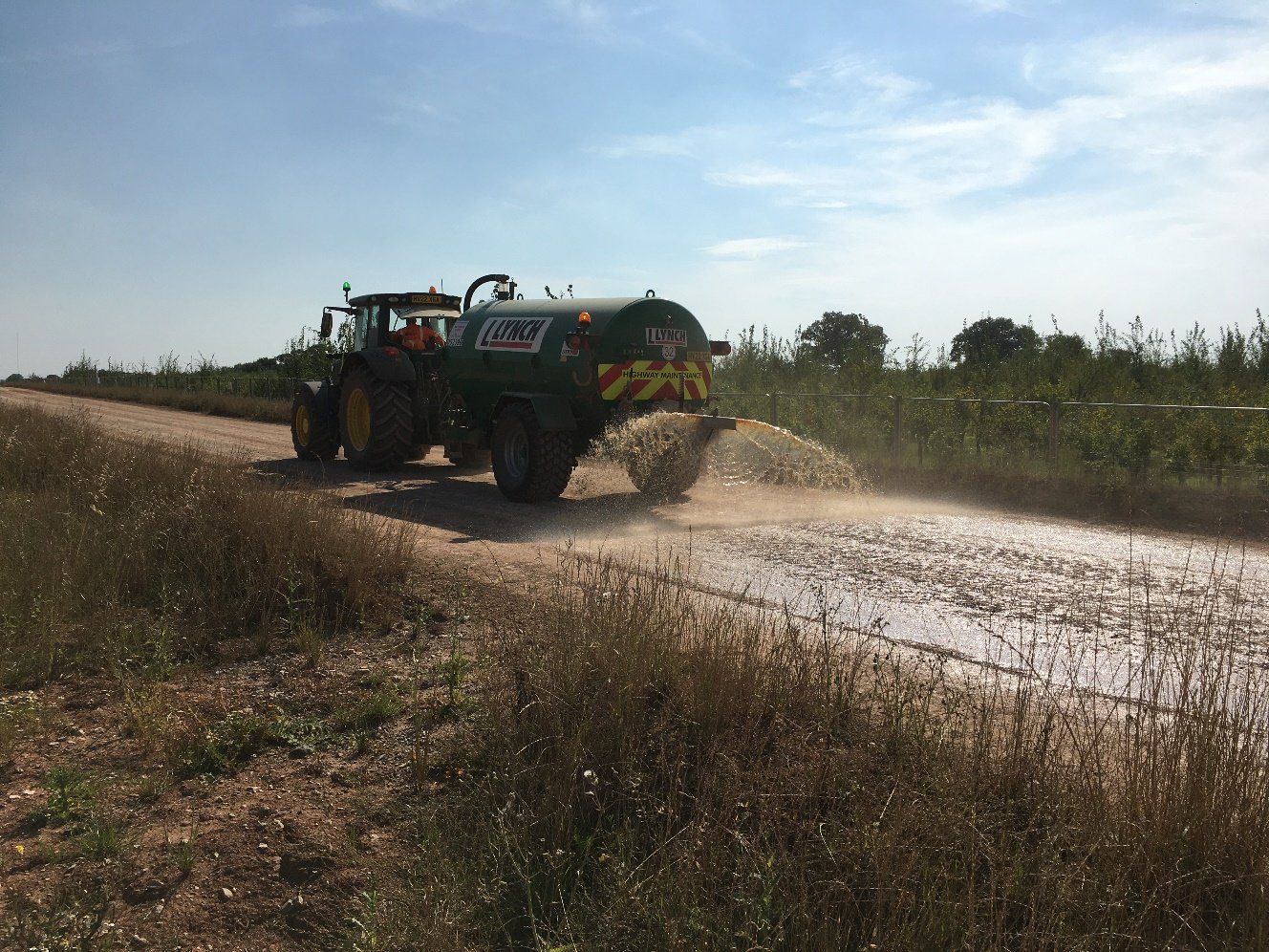 A tractor spraying dust spression on a haul road

